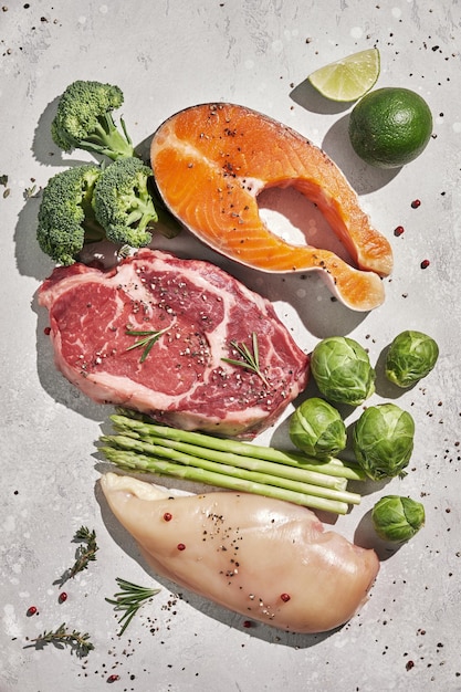 Assortimento di fonti proteiche sane e cibo per body building Carne di manzo salmone bistecca di pesce petto di pollo e verdure verdi