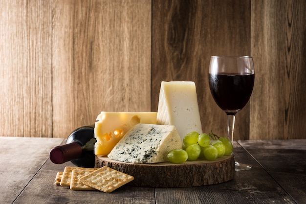 Assortimento di formaggi e vino sul tavolo di legno.