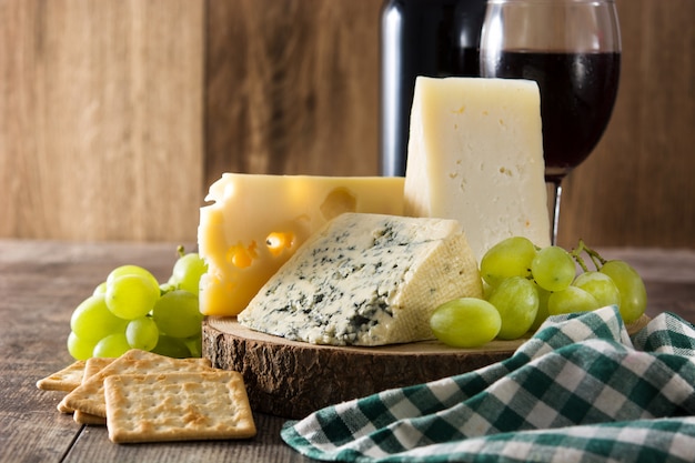 Assortimento di formaggi e vino sul tavolo di legno.