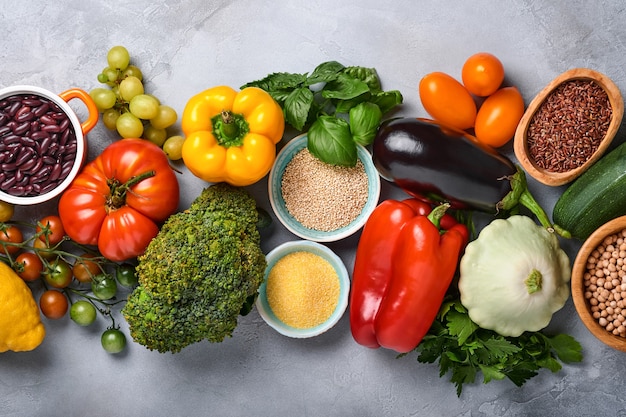 Assortimento di frutta fresca e verdure arcobaleno multicolore organiche su sfondo grigio cemento. Cucinare il cibo e sfondo di cibo sano e pulito e mock up.