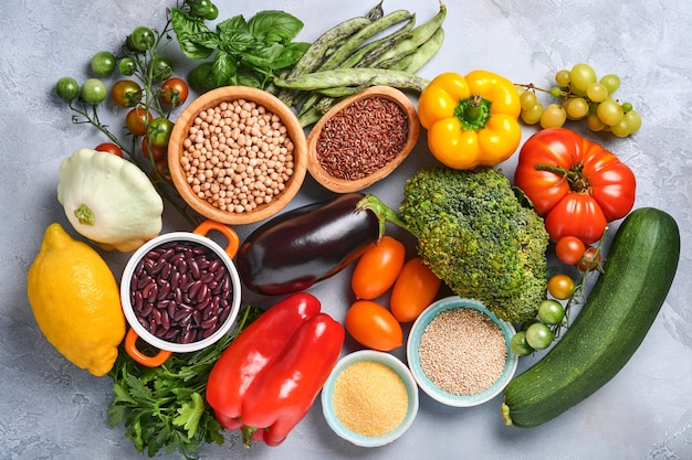 Assortimento di frutta fresca e verdure arcobaleno multicolore organiche su sfondo grigio cemento. Cucinare il cibo e sfondo di cibo sano e pulito e mock up.