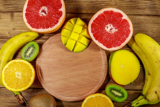 Assortimento di frutti tropicali su tavola di legno Natura morta con banane mango arance pompelmi e kiwi