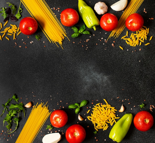 Assortimento di ingredienti alimentari italiani. Spaghetti, penne, mozzarella, basilico, pomodori, peperoni, rucola, aglio. Il concetto di cucina mediterranea e italiana. Vista dall'alto.