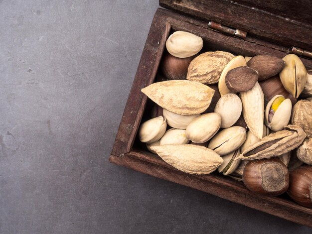 Assortimento di noci in una scatola di legno su uno spuntino sano sfondo nero Vista dall'alto