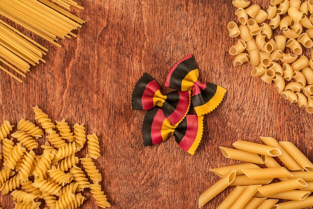 Assortimento di pasta di forma diversa sulla tavola di legno