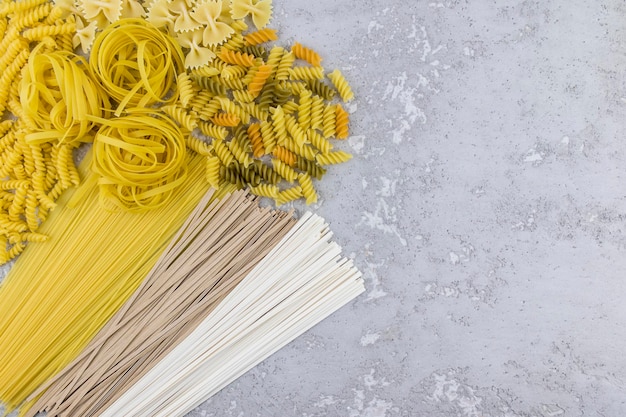 Assortimento di pasta secca italiana su fondo grigio cemento. vista dall'alto. una copia dello spazio.