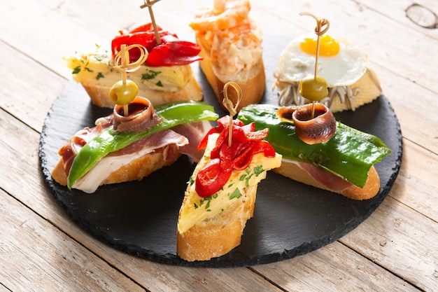 Assortimento di pintxos spagnoli su tavola di legno Cibo tipico spagnolo