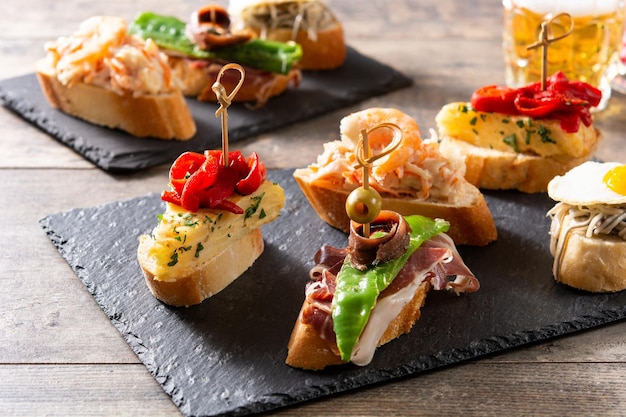 Assortimento di pintxos spagnoli su tavola di legno