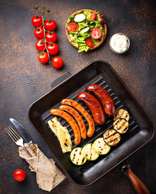 Assortimento di salsicce alla griglia e verdure in padella