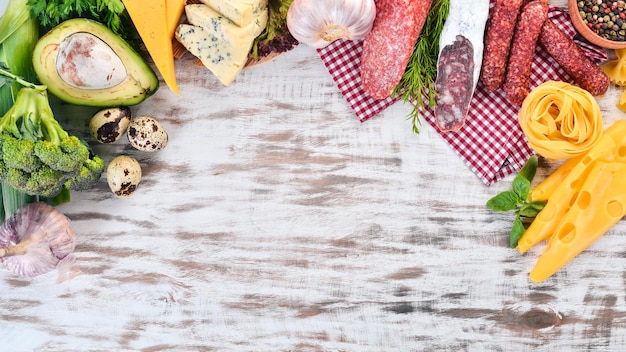 Assortimento di salsiccia e verdure fresche su uno sfondo di legno bianco Vista dall'alto Copia spazio