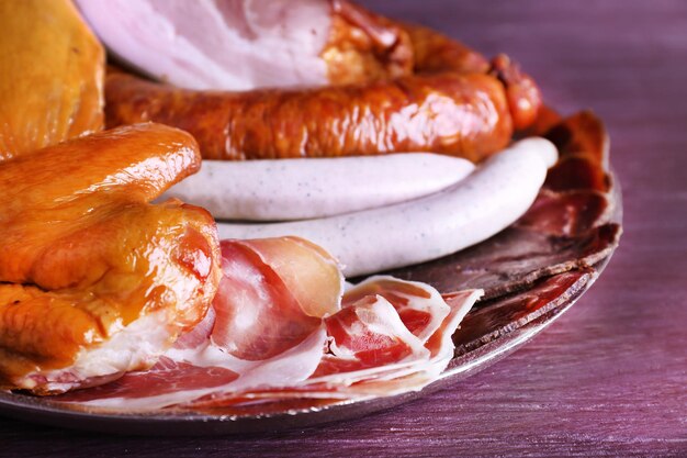 Assortimento di salumi su vassoio di metallo su fondo in legno colorato