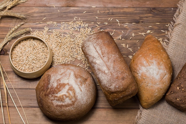 Assortimento di spighe di pane e chicchi di grano su tavola di legno Vista dall'alto in stile rustico