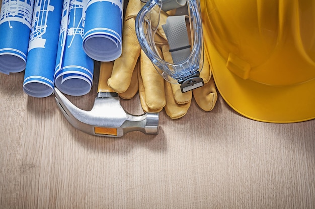 Assortimento di strumenti da costruzione su tavola di legno vista dall'alto.