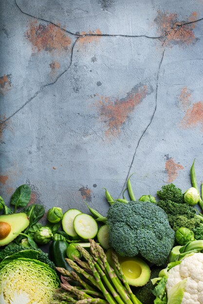 Assortimento di verdure verdi biologiche sane per un'alimentazione equilibrata. Vegano, vegetariano, cibo intero, a base vegetale, concetto di alimentazione pulita. Vista dall'alto sullo sfondo dello spazio della copia piatta