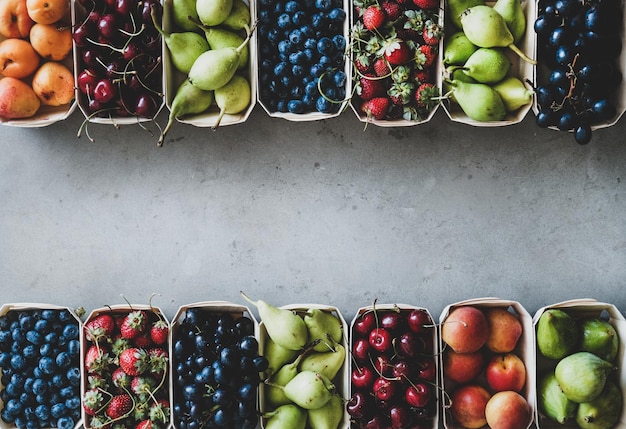 Assortimento estivo di frutta e bacche in scatole di legno copia spazio