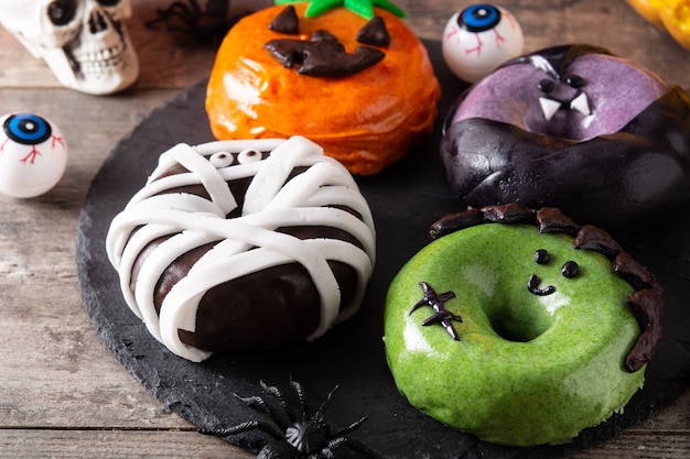 Assortitori di ciambelle di Halloween sul tavolo di legno