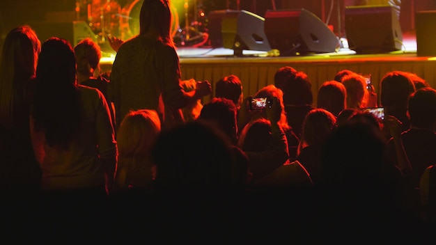 Astratto sfocato: le persone ascoltano un concerto rock in un club