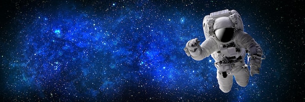 Astronauta che vola nello spazio esterno e aperto, che è behind.Abstract spazio sfondo con nebulosa viola blu e stars.sci-fi sfondo astratto spazio futuristico Elementi di questa immagine fornita dalla NASA.