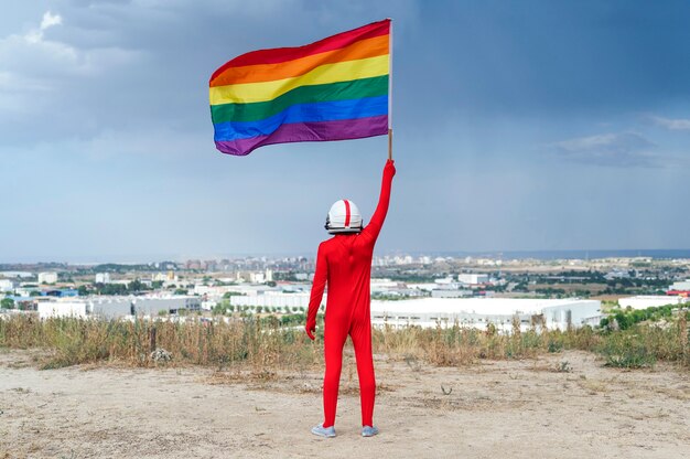 Astronauta con bandiera LGBT. Vista da dietro