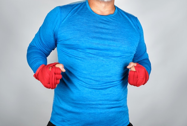 Atleta adulto in abiti blu, mani avvolte in un bendaggio elastico rosso
