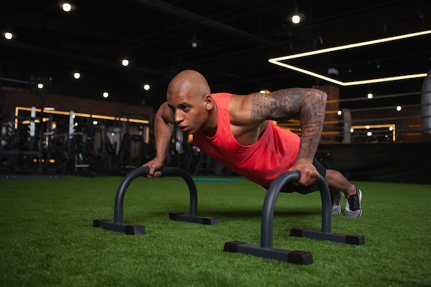 Atleta africano maschio bello che risolve in palestra