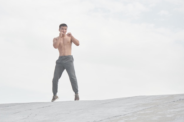 Atleta asiatico che si allena all'aperto al mattino, foto dell'allenamento del lottatore kazako in stile minimalista