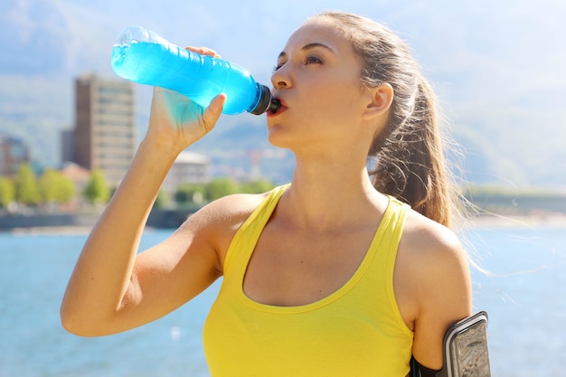 Atleta assetato che beve bevanda energetica dopo un lungo allenamento.