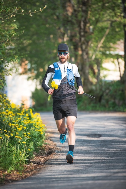 Atleta che corre con fiori gialli in mano