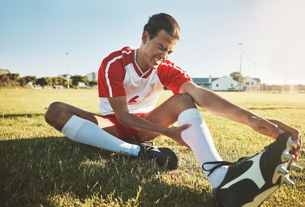 Atleta di calcio e infortunio sul campo sportivo durante l'allenamento e la pratica dell'esercizio soffrono il giorno della partita Salute del calcio e gamba dolorante a causa dell'allenamento o dolore muscolare per lo stiramento caduto o dolore al piede