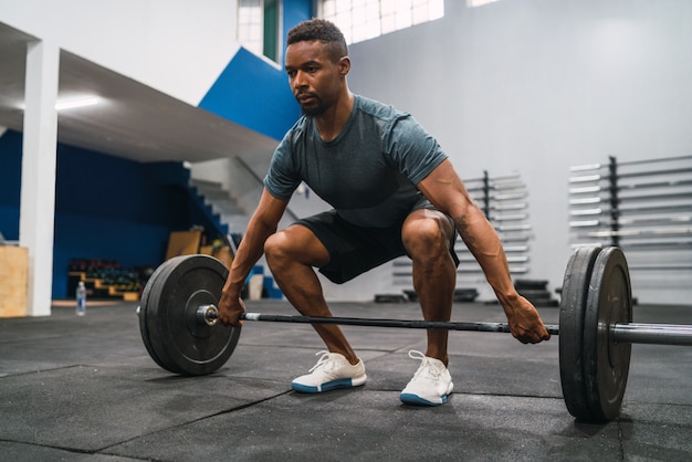 Atleta di Crossfit che fa esercizio con un bilanciere.