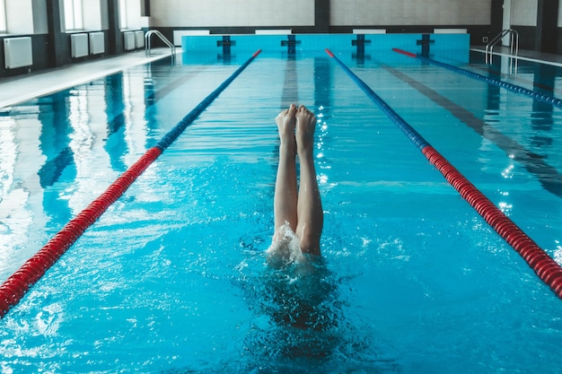 Atleta di nuoto sincronizzato si allena da solo in piscina