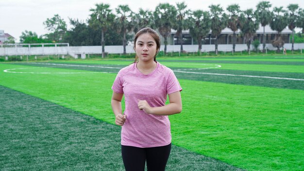 Atleta donna asiatica in esecuzione in pista