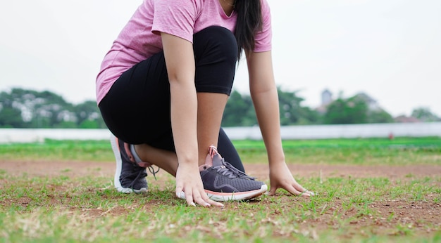 Atleta donna asiatica si prepara per iniziare a correre in pista