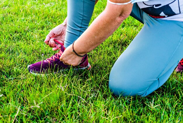 Atleta donna matura che si prepara a correre nel parco.