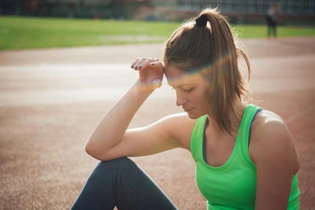 Atleta donna seduta sulla pista da corsa