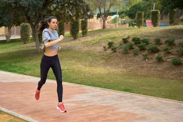 Atleta femminile che corre da solo sulla strada del parco