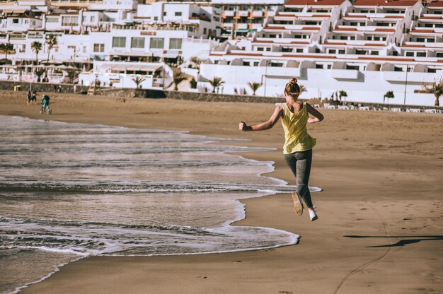 Atleta femminile in esecuzione in spiaggia