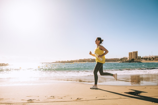 Atleta femminile in esecuzione in spiaggia