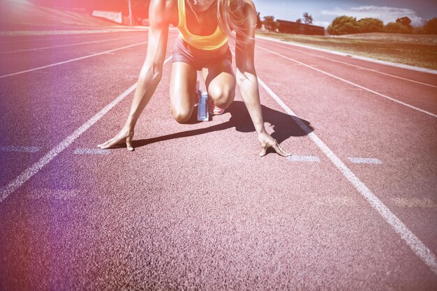 Atleta femminile pronto a correre sulla pista da corsa