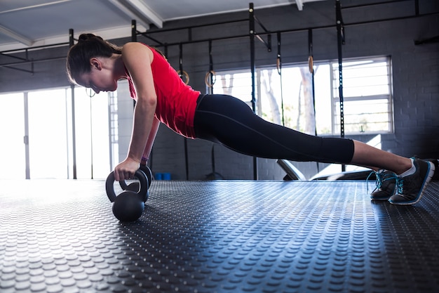 Atleta femminile sportivo facendo flessioni in palestra