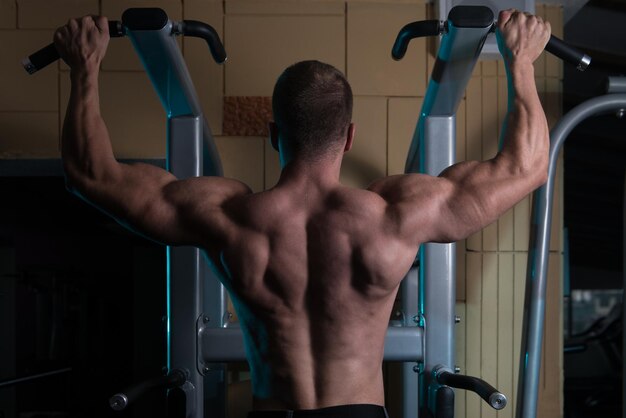 Atleta uomo che fa Pull Ups ChinUps in palestra