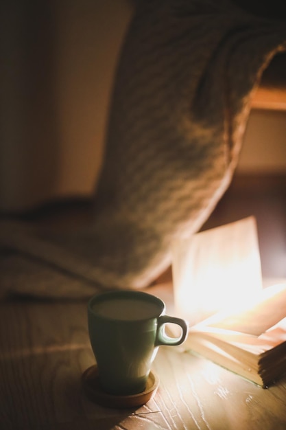 Atmosfera serale estetica calda e accogliente con un libro aperto e un soft focus scozzese