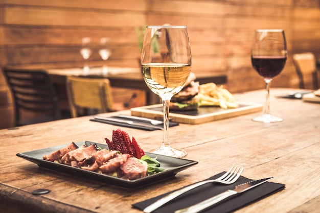 Atmosfera tradizionale del ristorante con tataki di tonno e hamburger con patatine