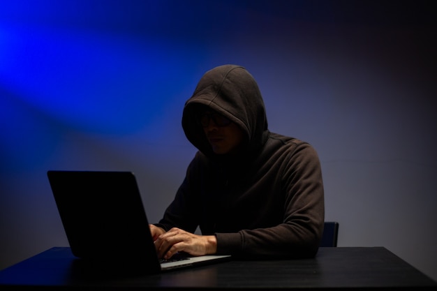 Attacco informatico che ruba informazioni con un programma per hackerare password e dati personali. Tastiera di digitazione hacker con laptop per sistema di ricerca e attacco.