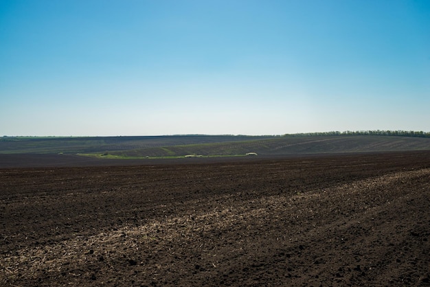 Atterra in un campo in primavera dopo aver arato sotto un cielo blu