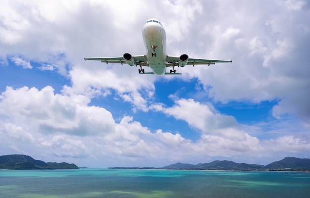 Atterraggio di aeroplano commerciale sopra il mare e cielo blu chiaro sopra la natura di uno splendido scenario.