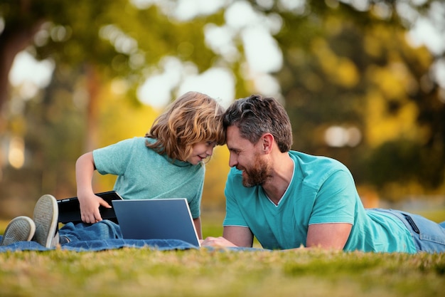 Attività del fine settimana concetto di stile di vita familiare felice padre con figlio usa il papà portatile e il bambino della scuola