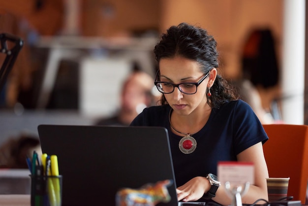 attività di avvio, donna che lavora su un computer portatile in un ufficio moderno