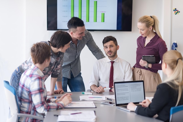 attività di avvio, giovani creativi di gruppo per il brainstorming sulla riunione all'interno dell'ufficio e l'utilizzo di laptop e tablet per annotare idee, piani e progetti