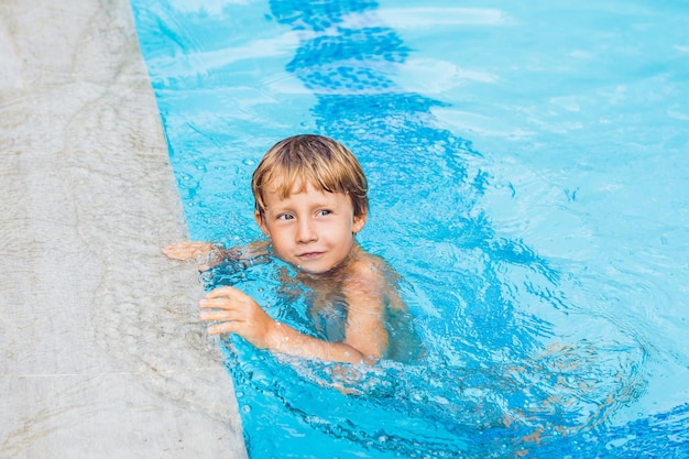 Attività in piscina, bambini che nuotano e giocano in acqua, felicità ed estate